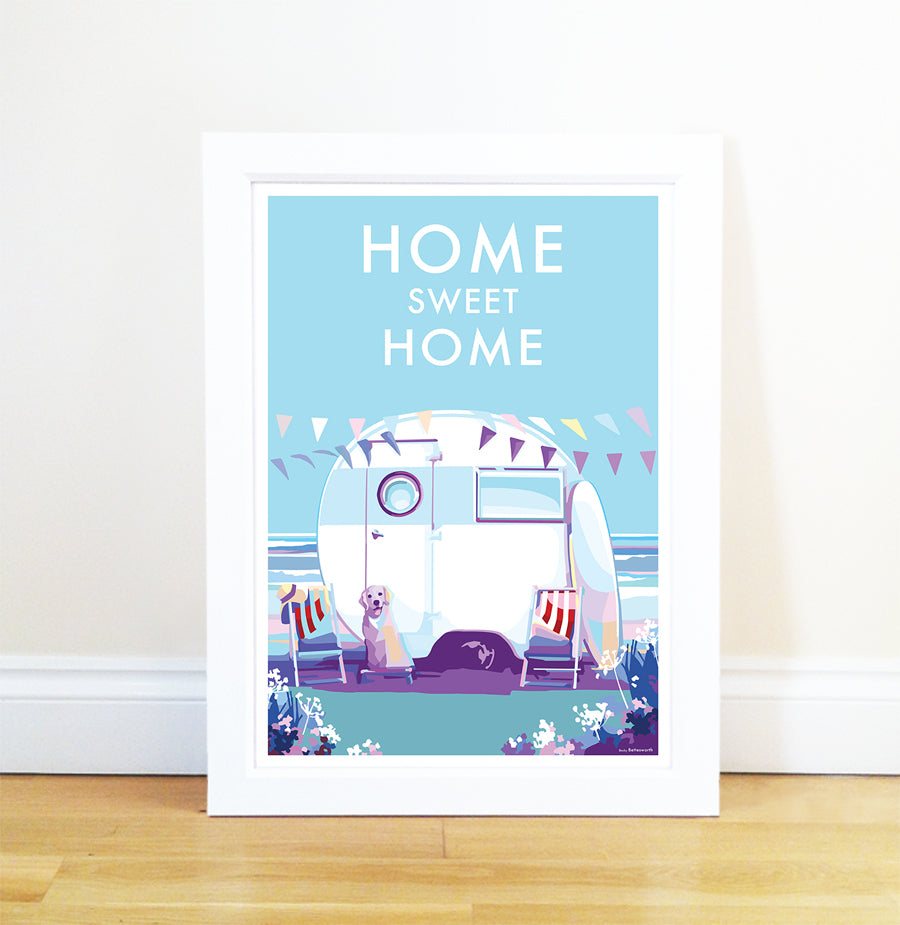 The Becky Bettesworth Home Sweet Home vintage-style quote poster showcases a framed caravan illustration by the beach with two dogs. Home Sweet Home text crowns the scene, while cheerful pennant flags evoke a perfect summer day.