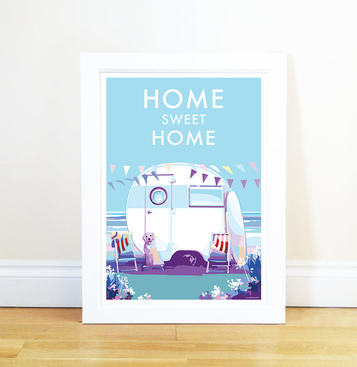 The Becky Bettesworth Home Sweet Home vintage-style quote poster showcases a framed caravan illustration by the beach with two dogs. Home Sweet Home text crowns the scene, while cheerful pennant flags evoke a perfect summer day.