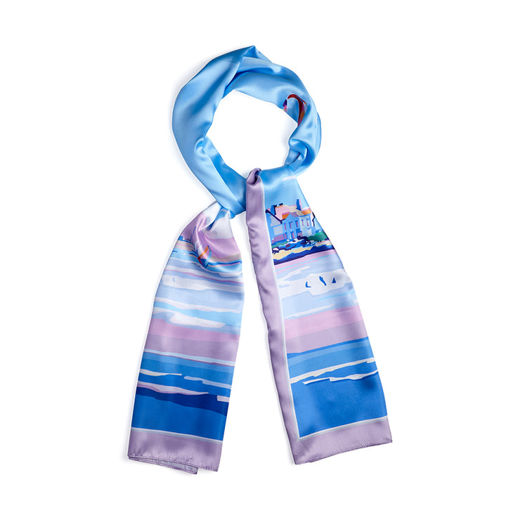 The BeckyBettesworth Luxury Long Satin Scarf boasts a modern vintage style with an abstract seascape in vibrant blue, purple, and pink hues and small houses near the shore, elegantly arranged in a circular shape on a white background.